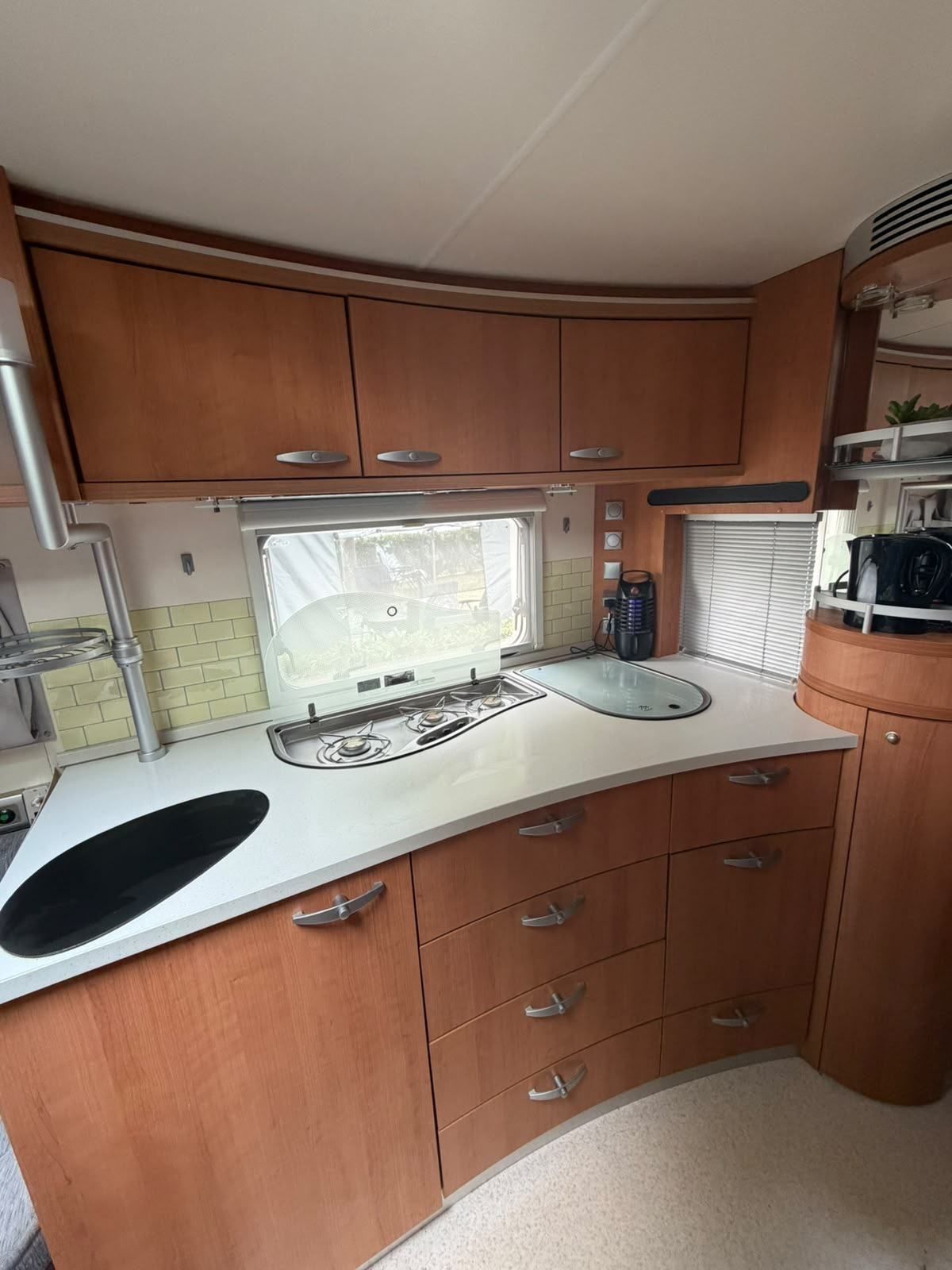 Caravan kitchen with hob, sink and wooden cupboards