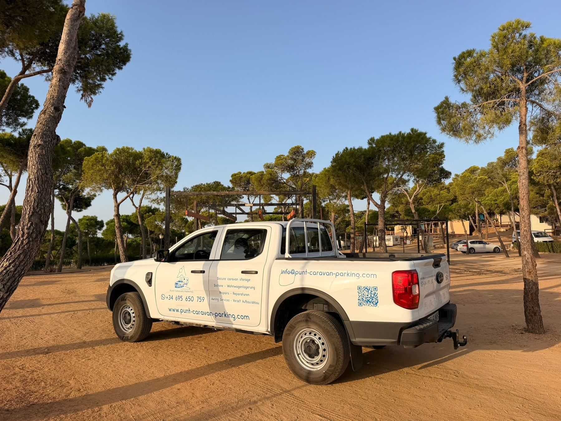 Punt pickup parked on a sandy campsite under pine trees